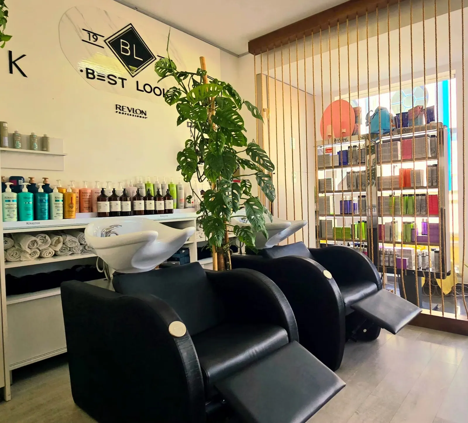Interior sereno do salão Best Look — cadeiras de lavagem, plantas e produtos premium de saúde capilar